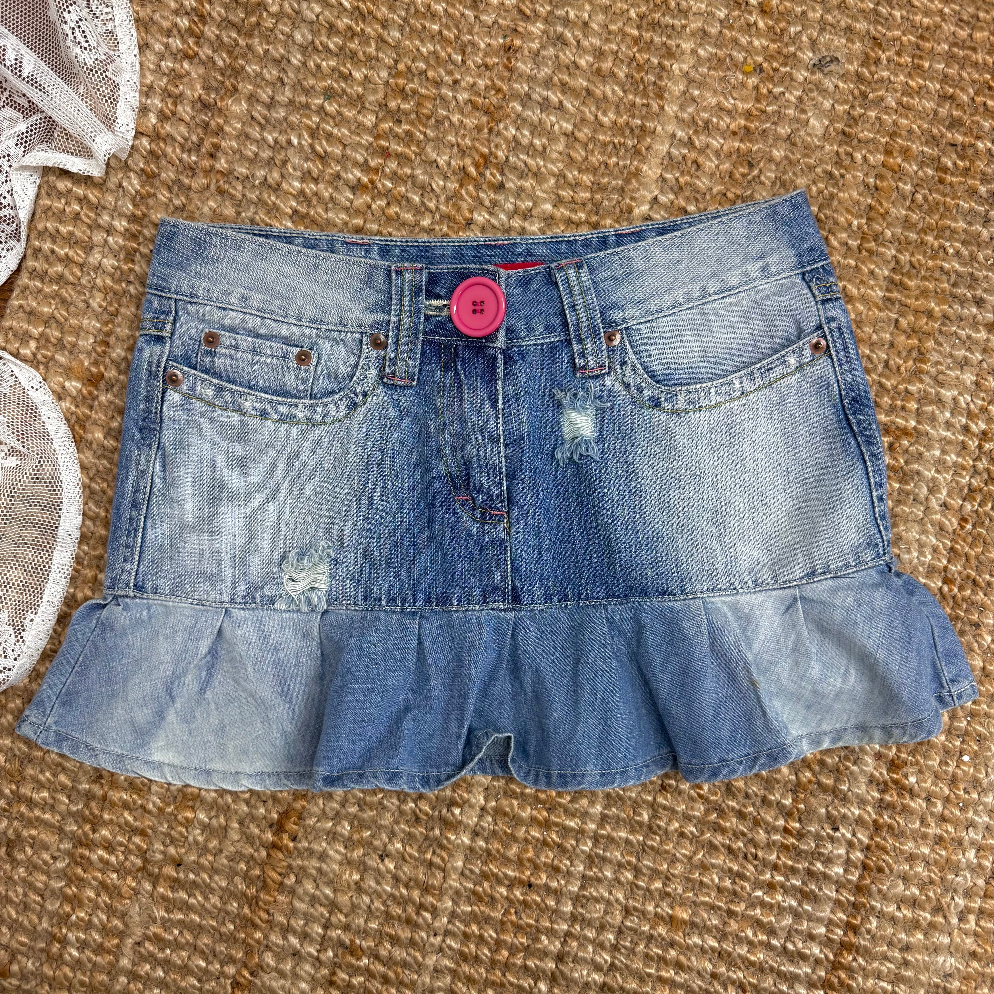 Blue denim ruffled mini skirt with pink button