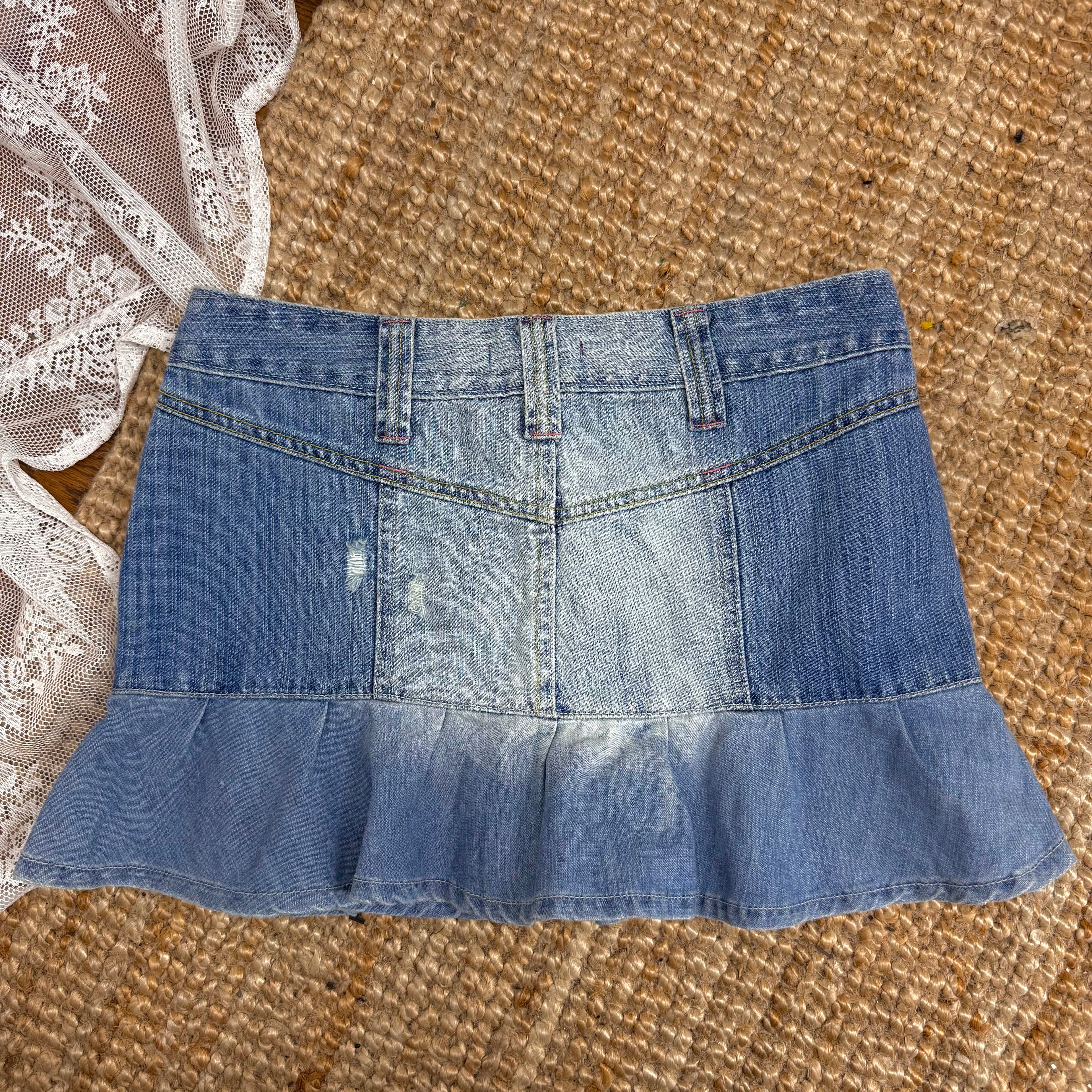 Blue denim ruffled mini skirt with pink button