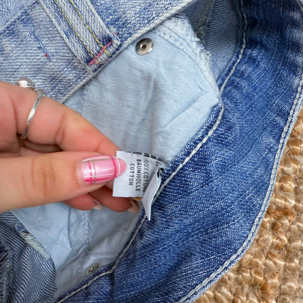 Blue denim ruffled mini skirt with pink button