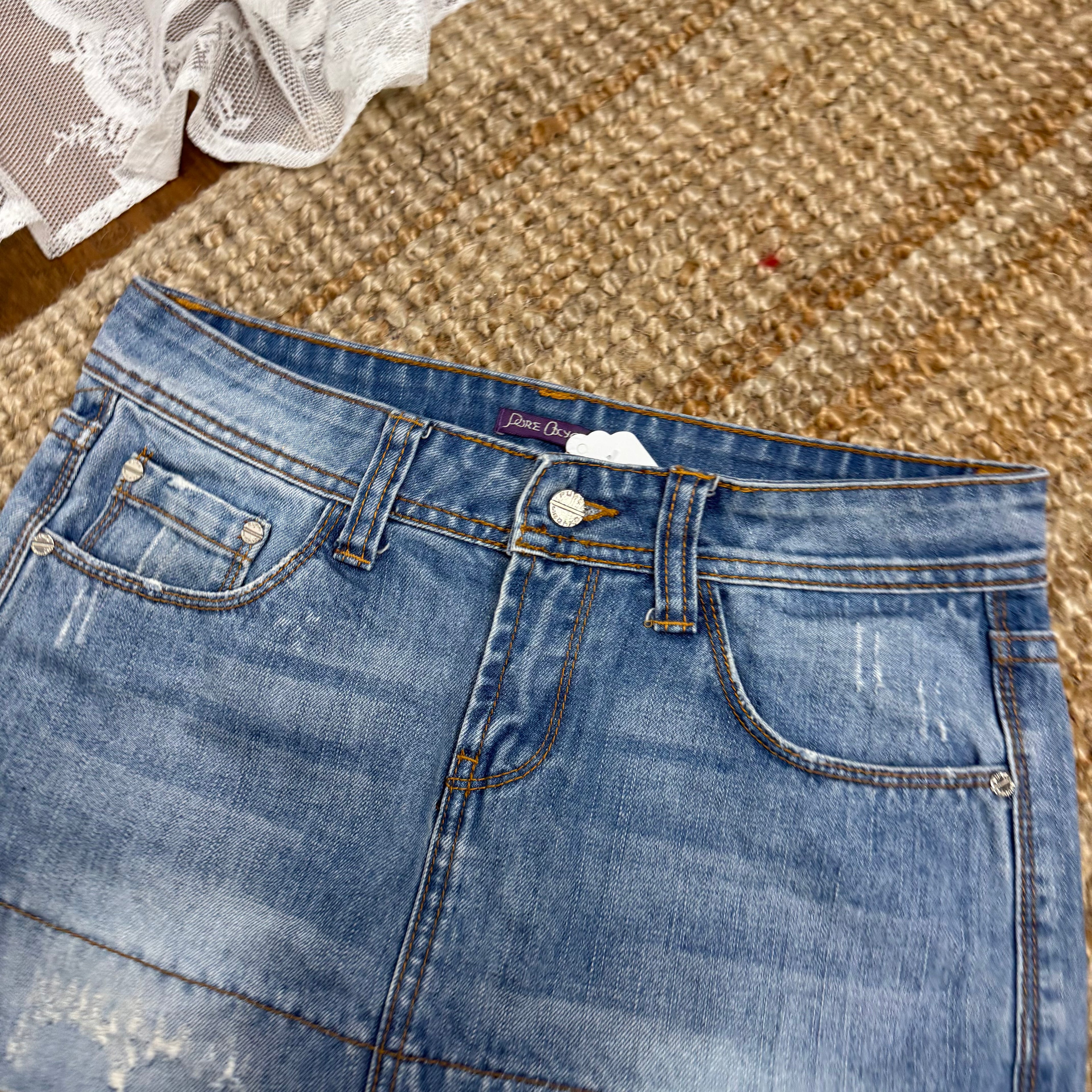 Light blue denim mini skirt with distressed detailing